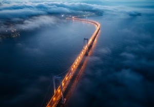 A bridge over water covered by fog
